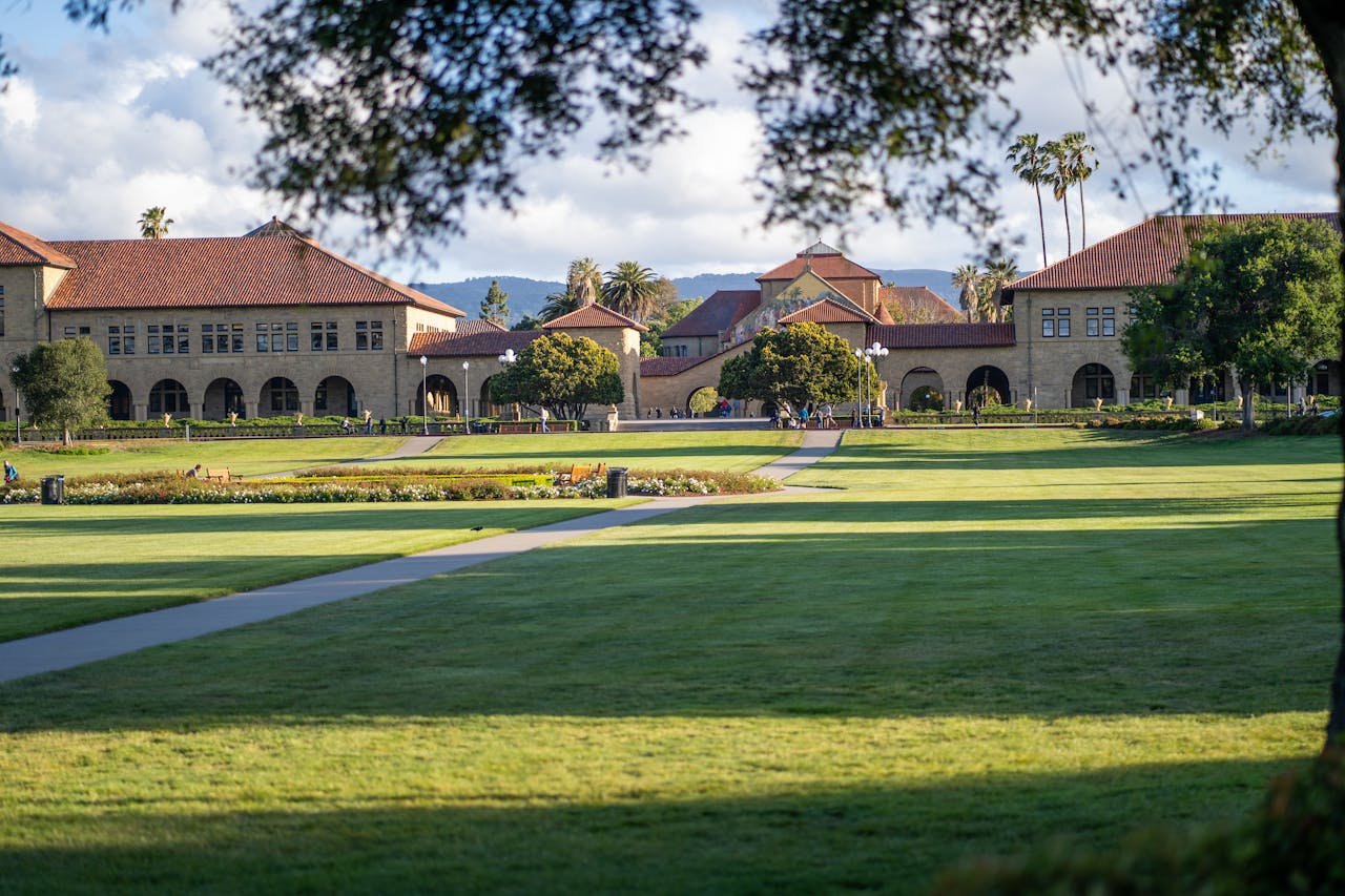service-02 Serene view of Stanford University's iconic campus buildings and lush gardens.