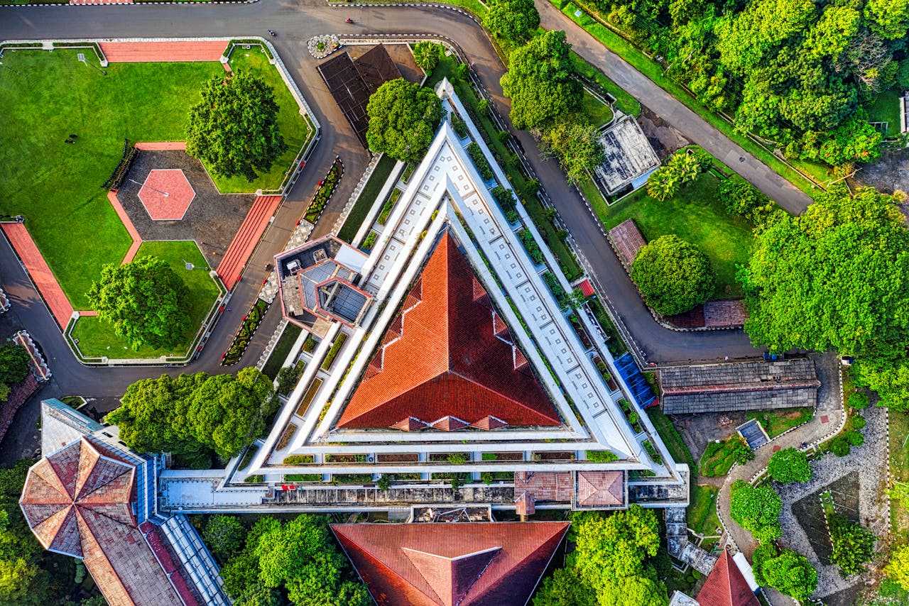 Stunning aerial view of the unique triangular architecture at Bogor Agricultural University, highlighting its vibrant red roofs and lush surroundings.